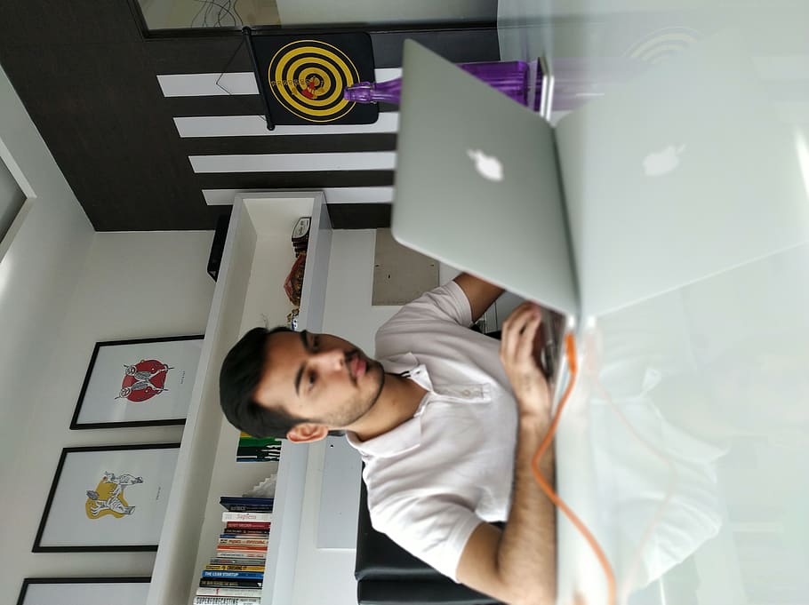 man using MacBook on table, one person, real people, young adult HD wallpaper