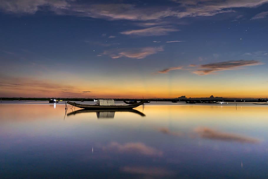 White and Black Boat on Body of Water Under Blue and Gray Skies HD wallpaper