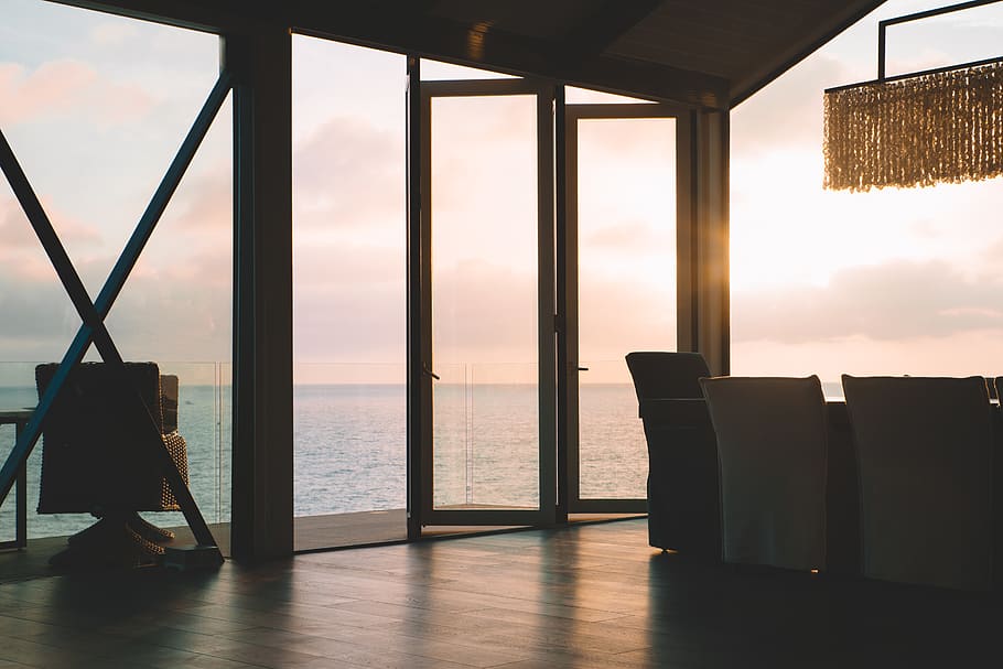 white wooden framed glass window beside blue sea, flooring, chair