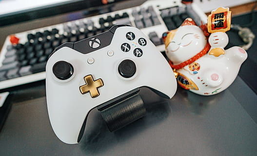 White and Black Xbox One Wireless Controller Beside White and Multicolored Ceramic Cat Figurine on Black Surface HD wallpaper