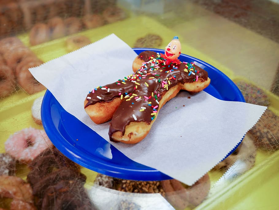 Clown donut sitting on a blue plate in a donut shop., bakery HD wallpaper