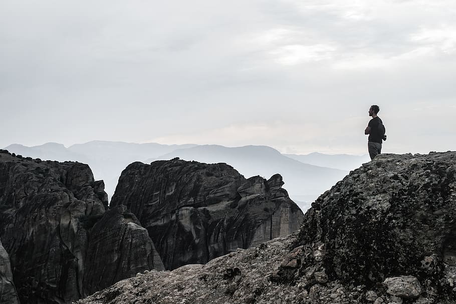man standing on cliff wallpaper, greece, meteora, mountain, nature HD wallpaper