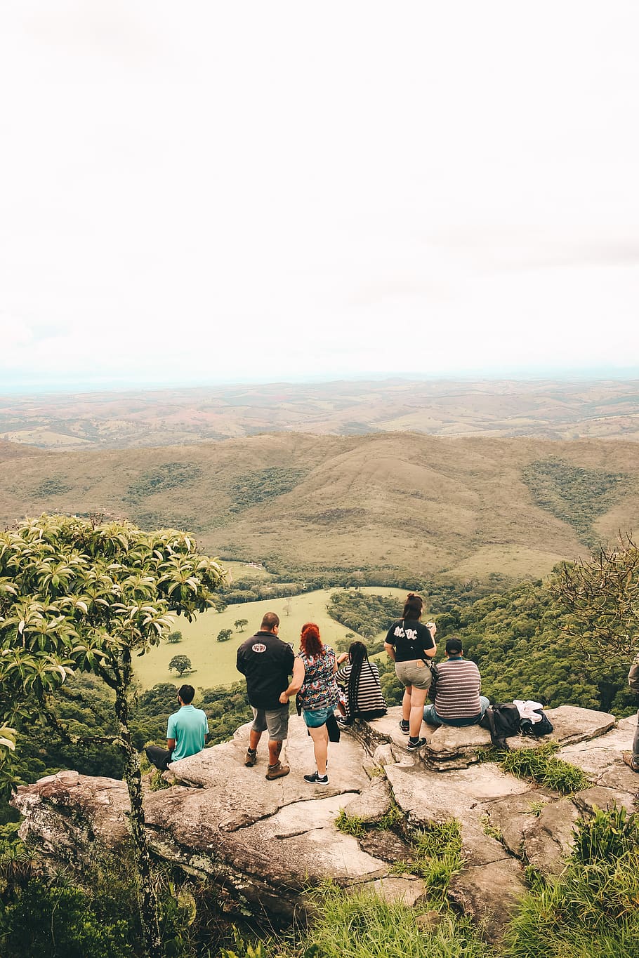 People Sitting and Standing on the Edge If Cliff, clouds, daylight HD wallpaper