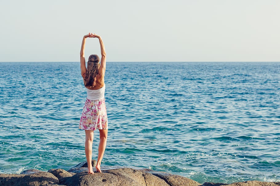 Woman Standing on Rock by the Sea, back view, beach, blue, female HD wallpaper