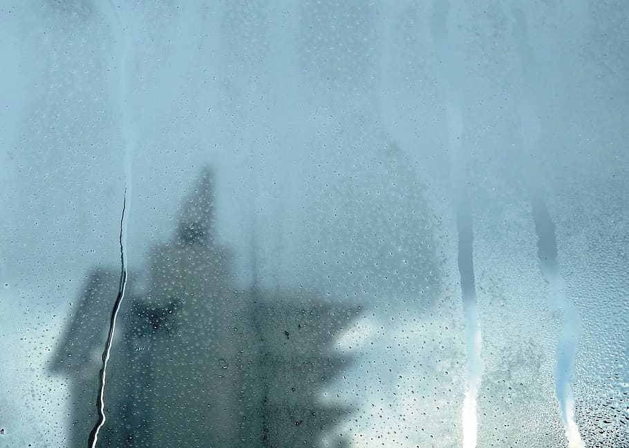 Urban abstract background of a tower block seen through a misted window with raindrops