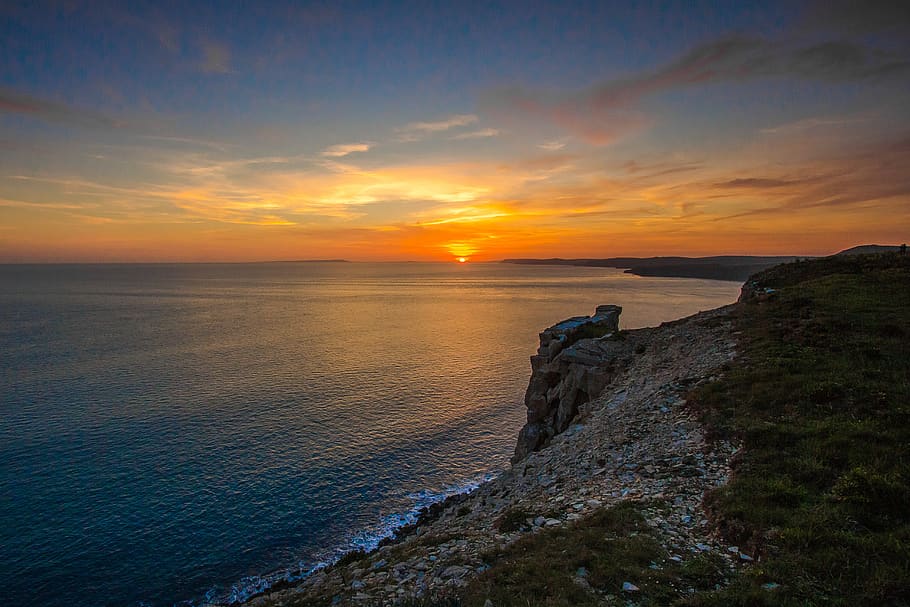 Body of Water Near Mountain, cliff, clouds, coast, dawn, grass HD wallpaper