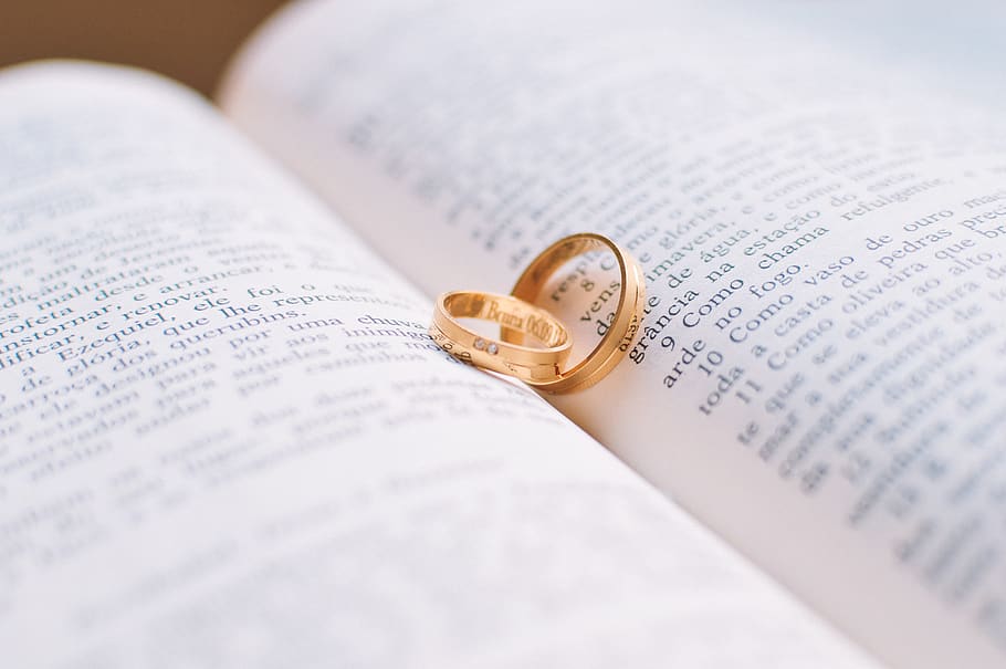 Two Gold-colored Wedding Bands on Book Page, bible, golden ring