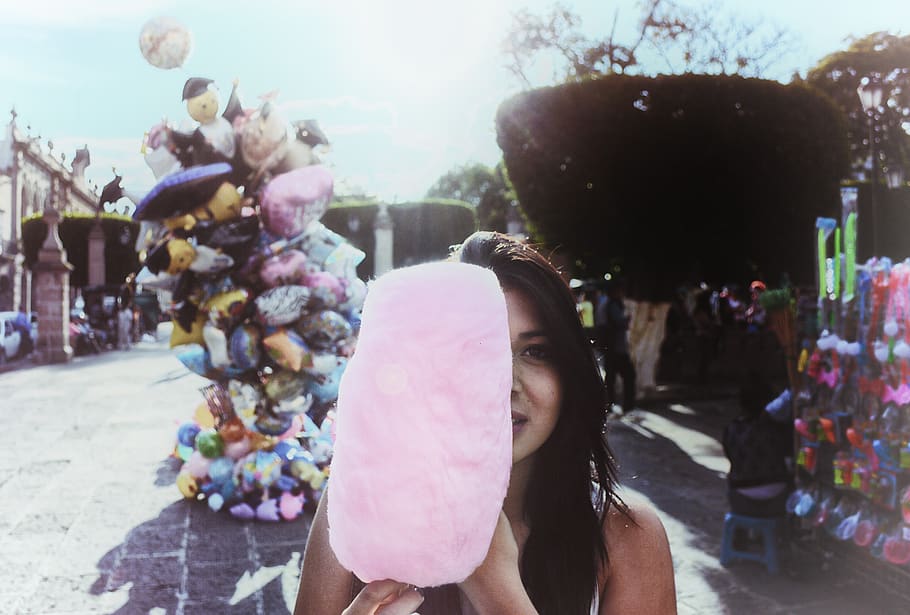 Woman Holding Cotton Candy With Balloons in Background, celebration HD wallpaper