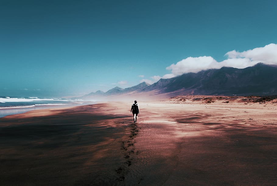 Photo of Person Walking on Deserted Island, beach, blue skies
