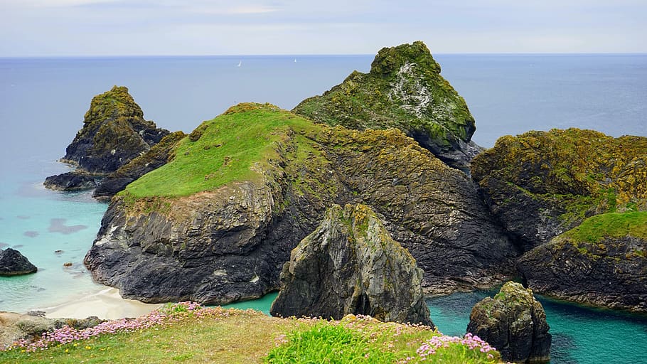 Rock Formation Coated With Green Grass on Body of Water, beach HD wallpaper