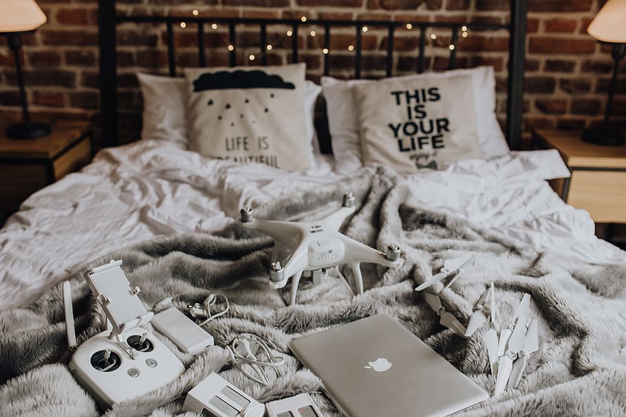 Drone, laptop and accessories lie on the bed ready for travel HD wallpaper