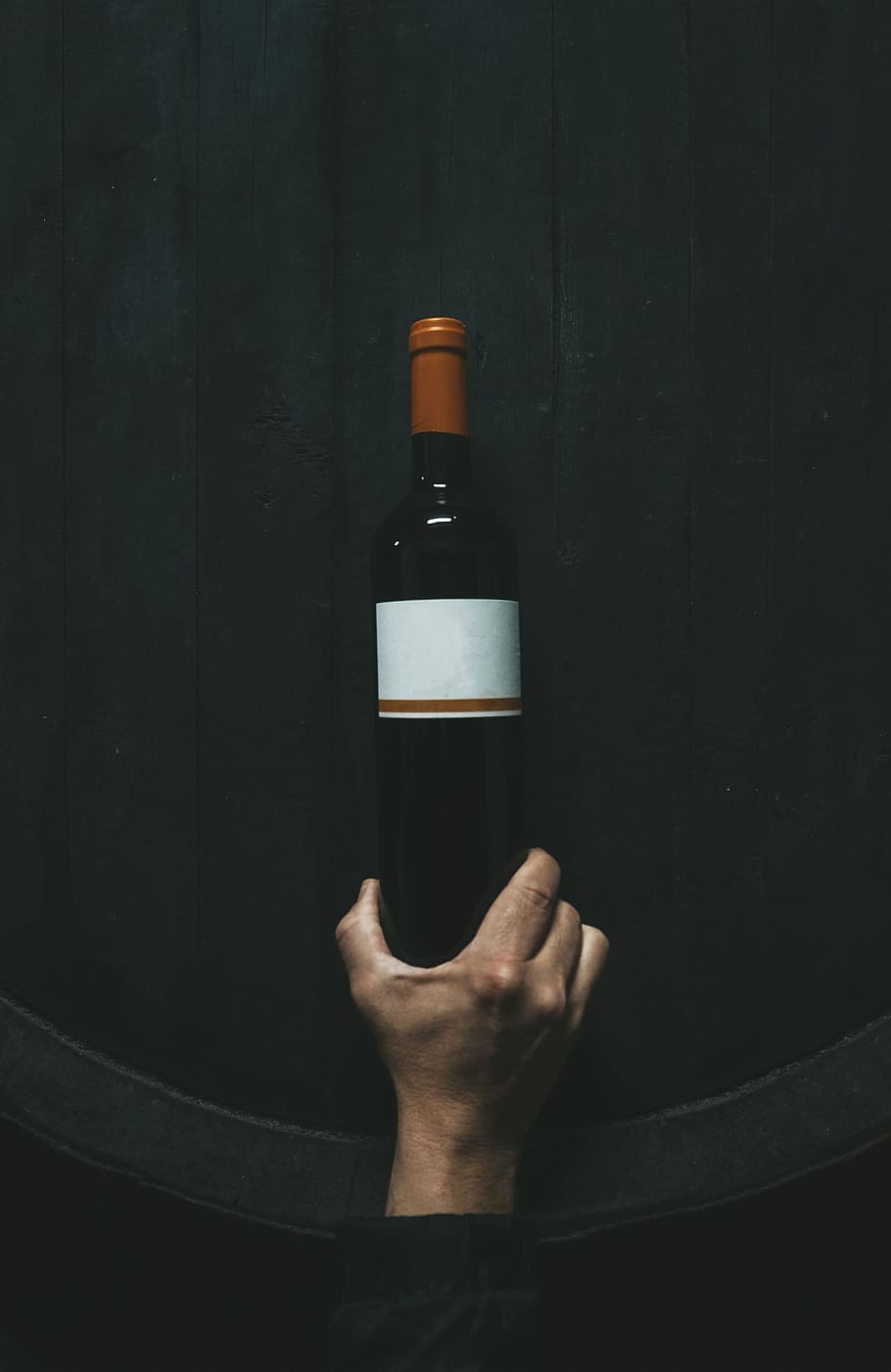 person holding white labeled bottle, wood, hand, wine, bodega