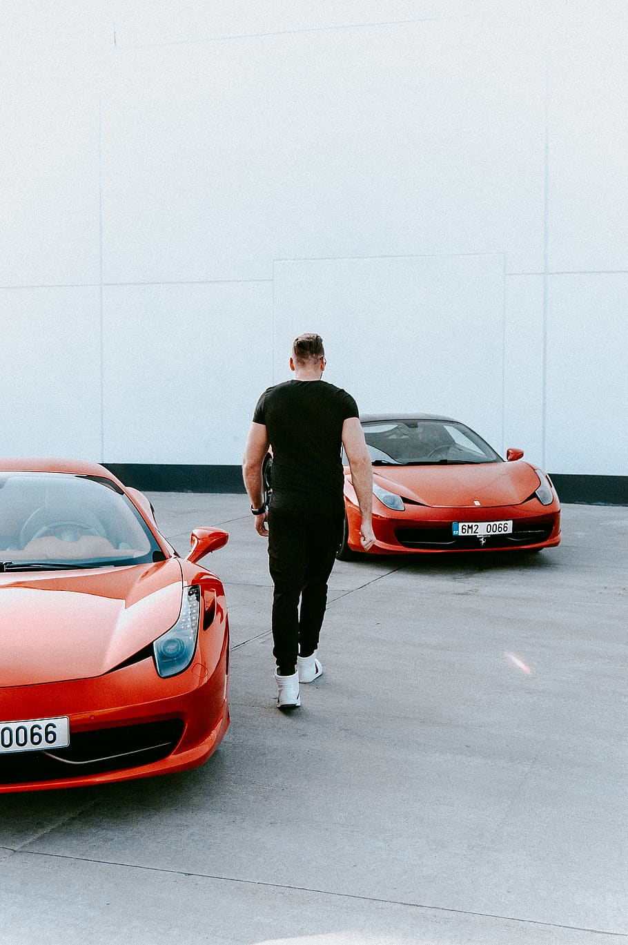 man walking between red vehicles, car, motor vehicle, transportation HD wallpaper