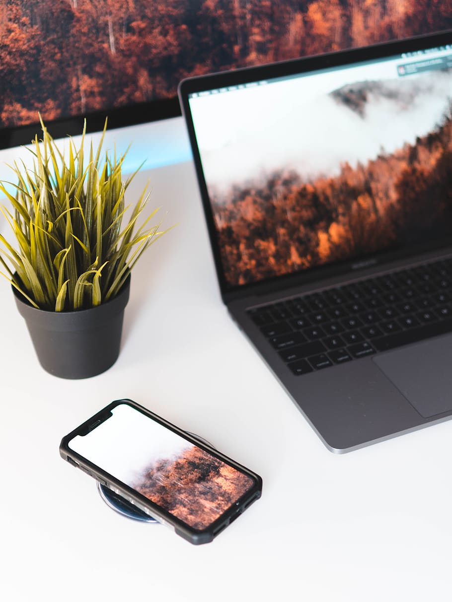 turned-on MacBook Pro, iphone x, white desk, wireless charger HD wallpaper