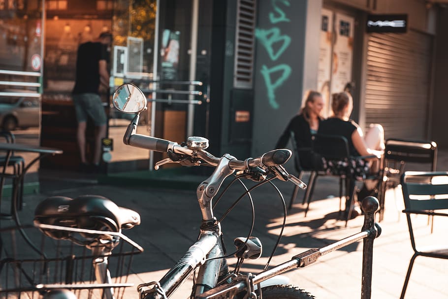 parked bicycle near store front during daytime, focus on foreground HD wallpaper