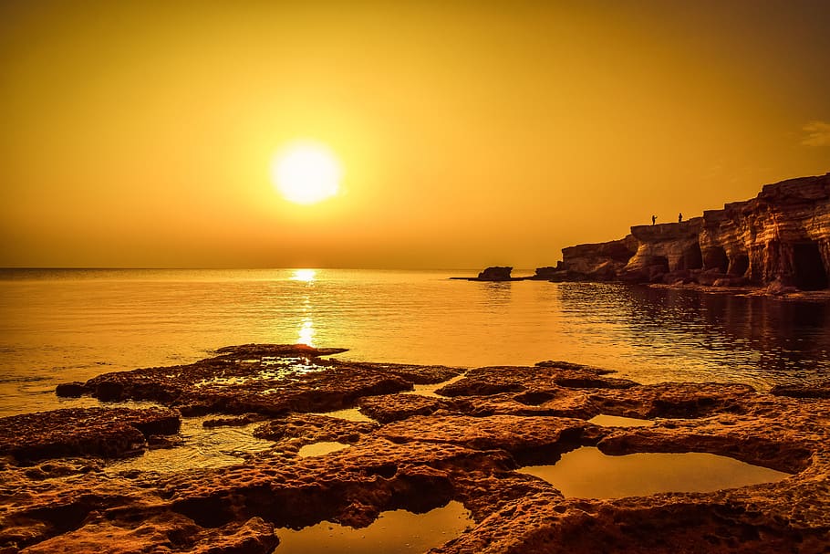 sunset, dusk, sea, water, rock, cliff, shadows, landscape, orange HD wallpaper