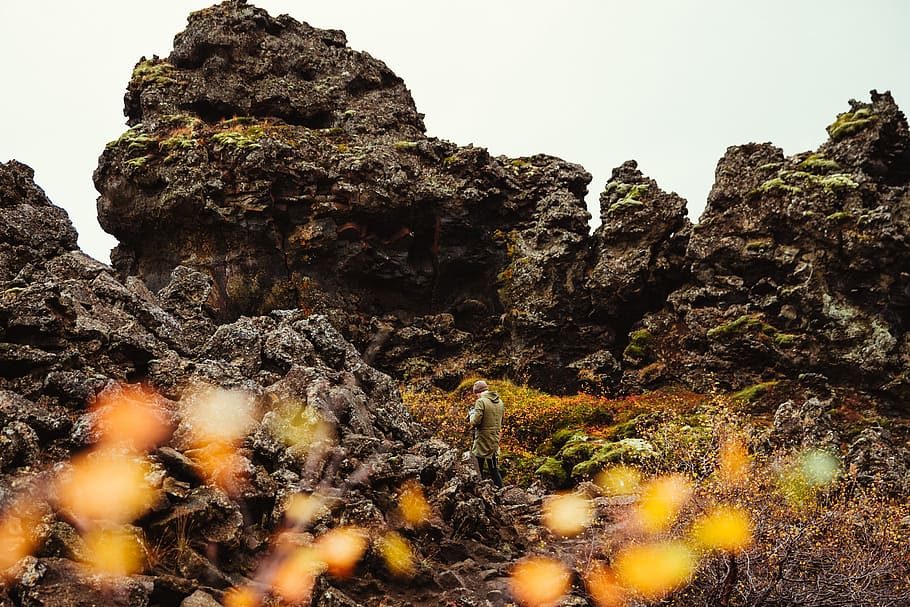 A photographer at volcanic rocky hills covered with grass, adventure HD wallpaper