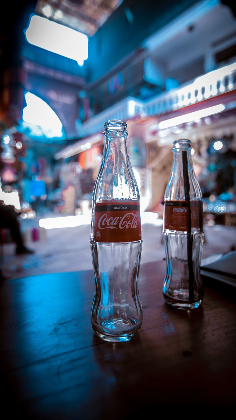 two empty Coca-Cola soda bottles on brown table, alcohol, beverage