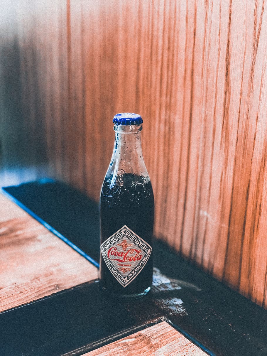 Coca-Cola bottle on brown and black surface, drink, beverage