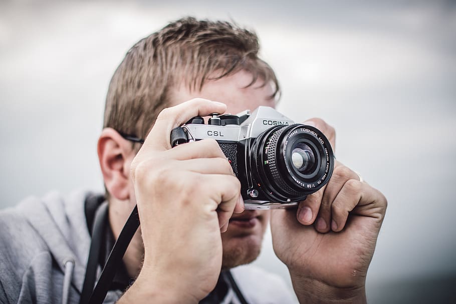 Man Holding Black Silver Bridge Camera Taking Photo during Daytime HD wallpaper
