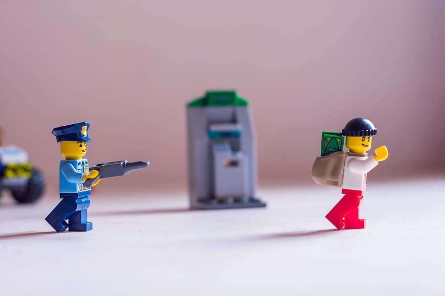 A Lego police officer pointing his gun at a robber., india, thiruvananthapuram