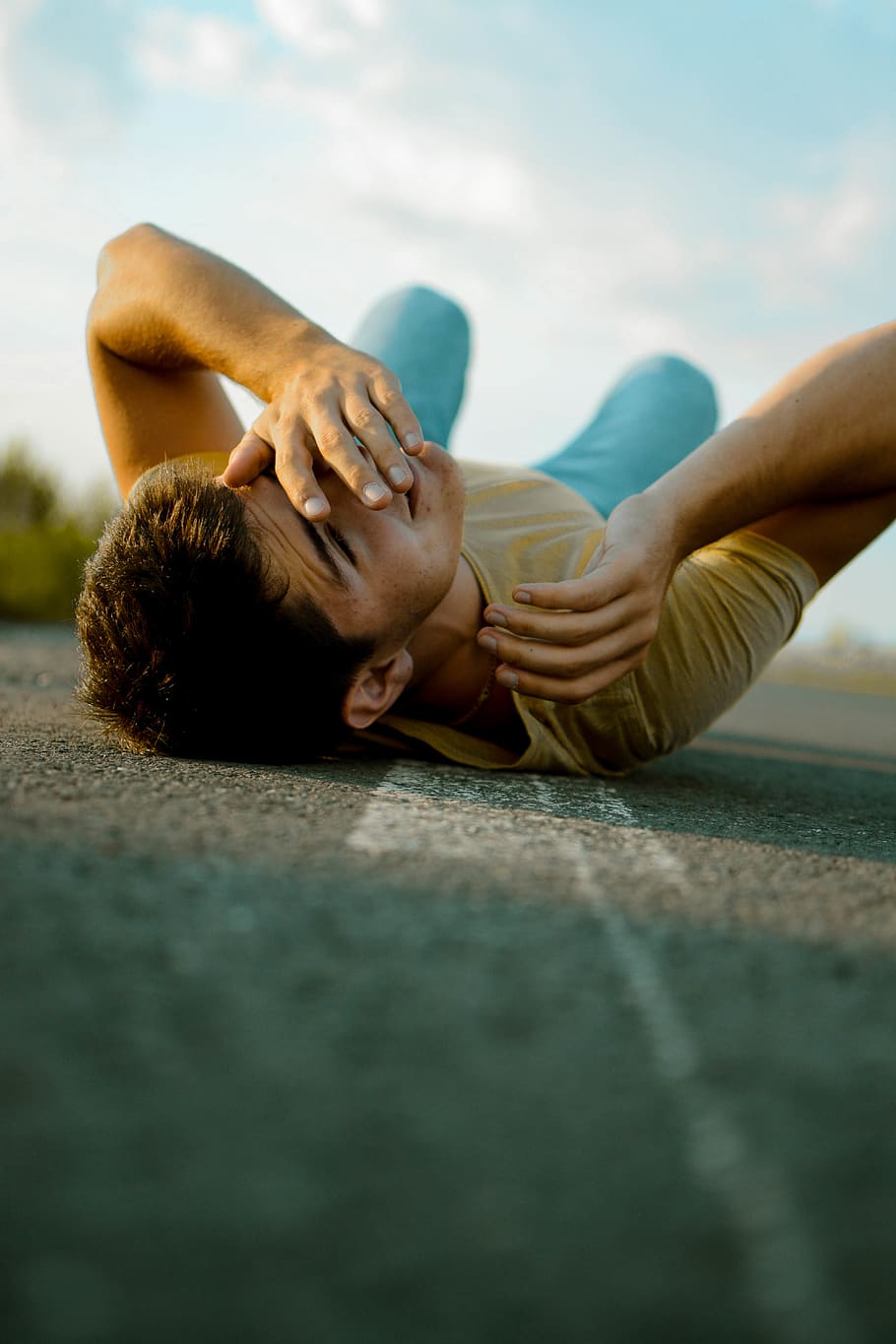 man lying on road during daytime, lying down, real people, human hand HD wallpaper