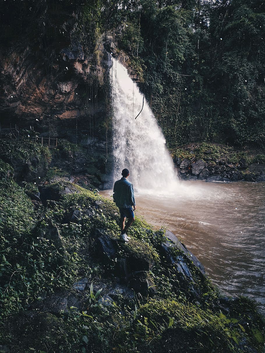 Man Standing Beside Waterfalls, adventure, cascade, daylight HD wallpaper