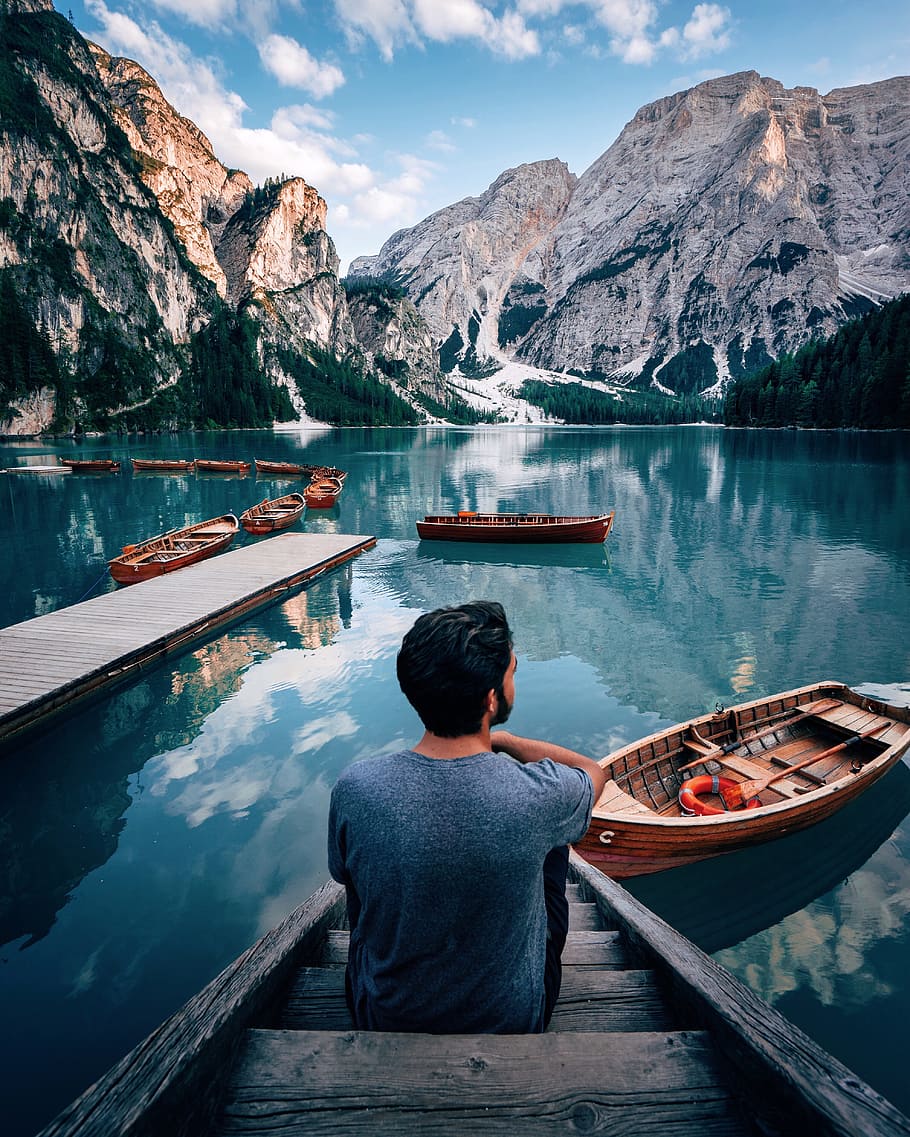 man sitting on brown wooden stairs staring out lake near mountain during daytime, HD wallpaper