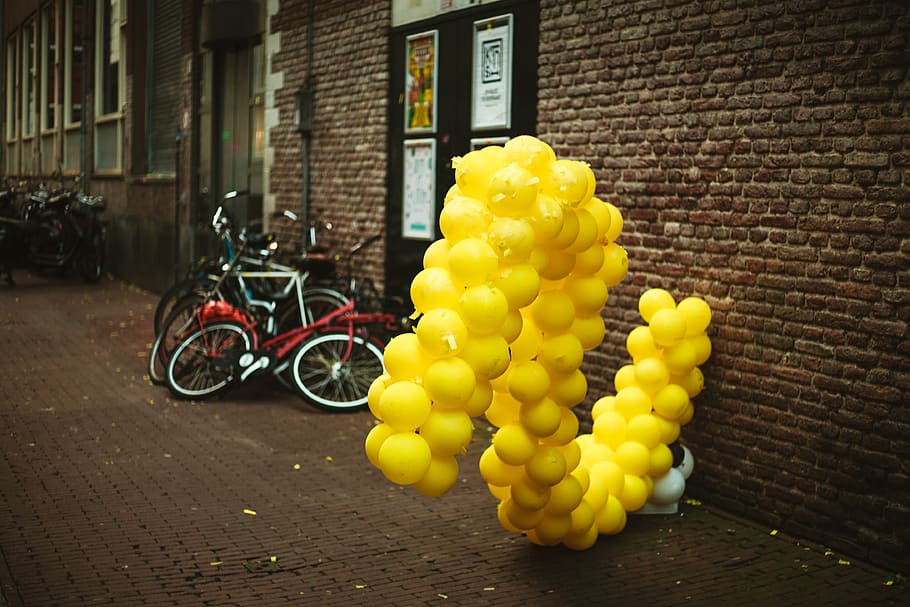 yellow balloons near parked bikes, wheel, machine, vehicle, transportation