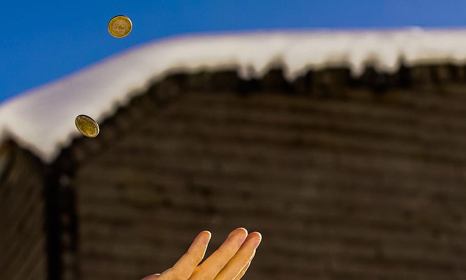 Shallow Focus Photography of Person Catching Two Gold-colored Coins HD wallpaper
