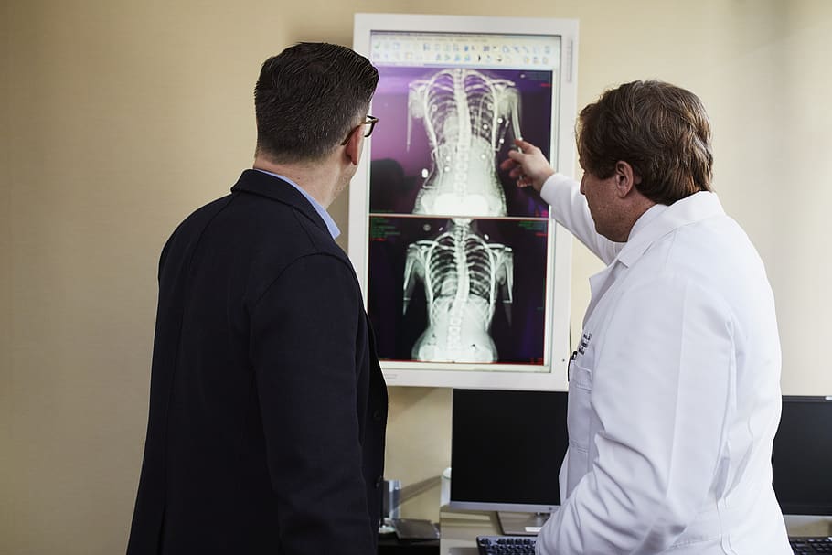 HD wallpaper: Doctor Pointing X-ray Result Beside Man Wearing Black Suit, explaining - Wallpaper Flare