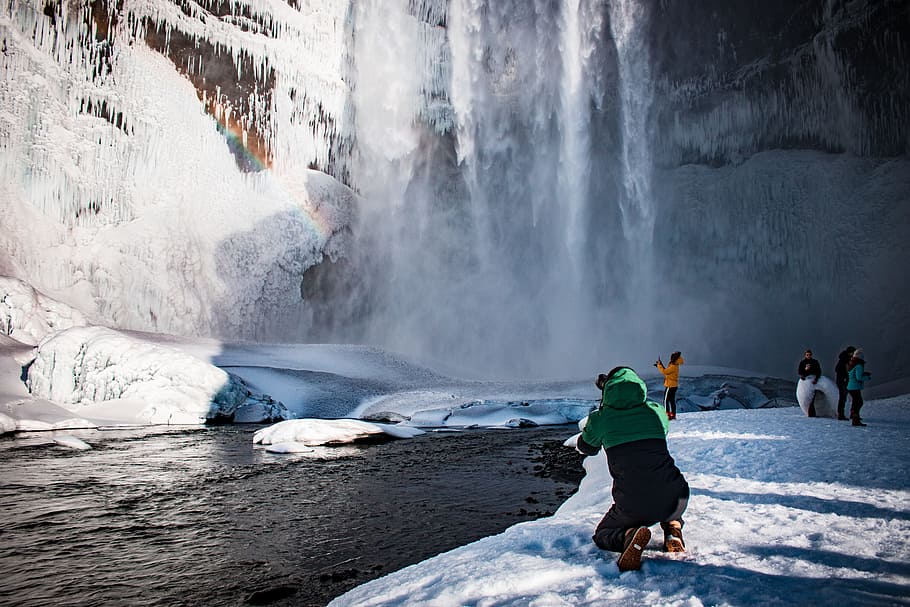 person kneeling beside body of water, waterfall, mountain, cold HD wallpaper