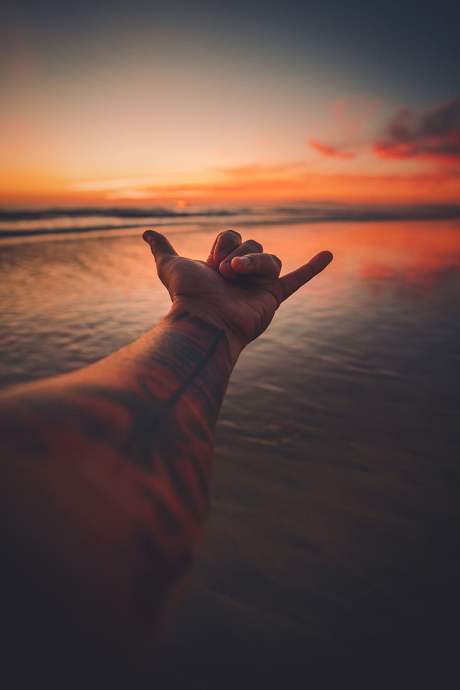 left person's hand, sign, chill, adventure, moody, red, dusk