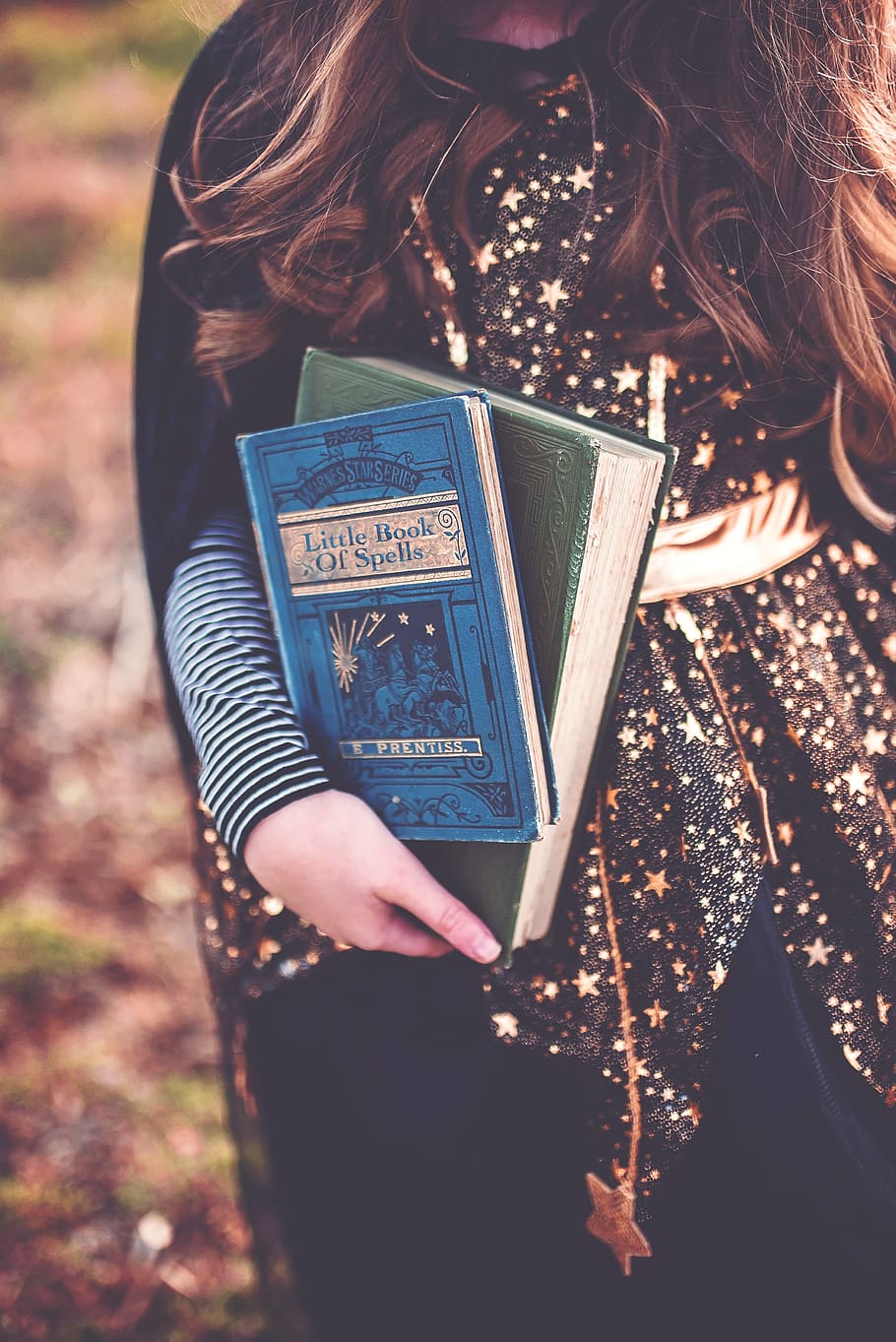 person holding two books, magic, magical, star, wicked, spooky
