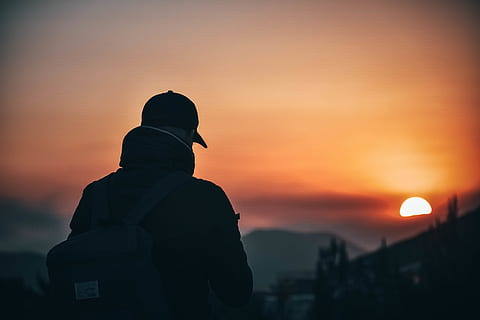 Man Wearing Baseball Cap and Backpack at Golden Hour, back view HD wallpaper