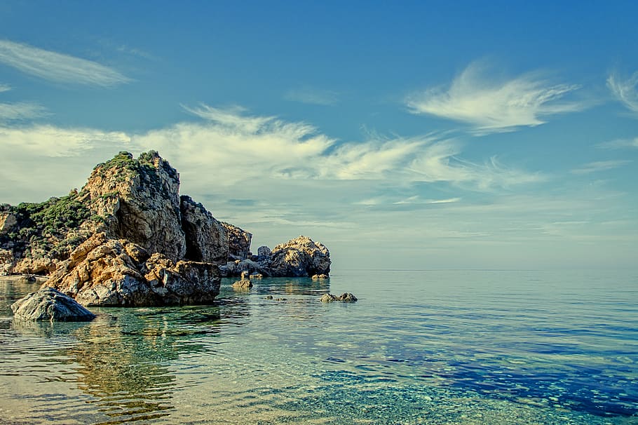 Cliff and Rock Formations on Calm Body of Water during Daytime HD wallpaper