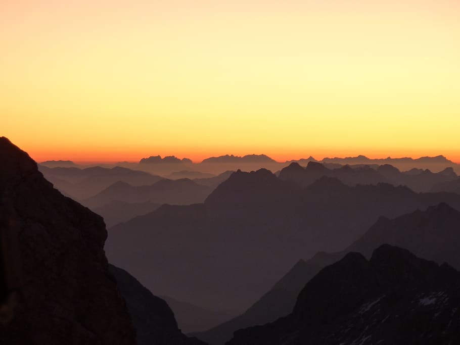 Silhouette of Hills Under Orange and Yellow Sky during Sunset HD wallpaper
