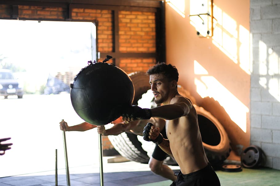 Man in Black Shorts Punching Black Ball, action, active, athlete