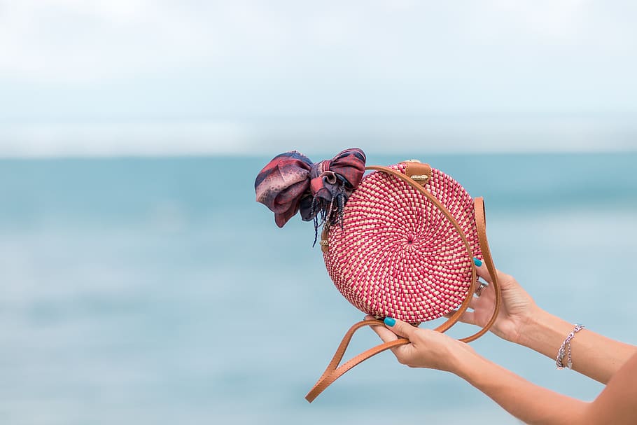 Selective Focus Photography of Person Holding Red and Brown Leather Crossbody Bag HD wallpaper