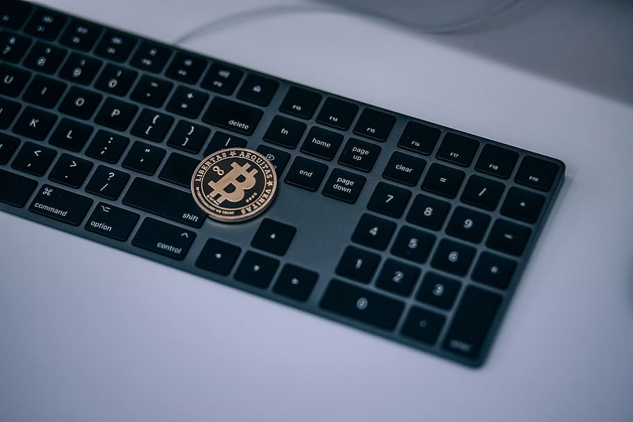 Physical Golden Cryptocurrency Bitcoin Placed on Top of a Black Apple Keyboard HD wallpaper