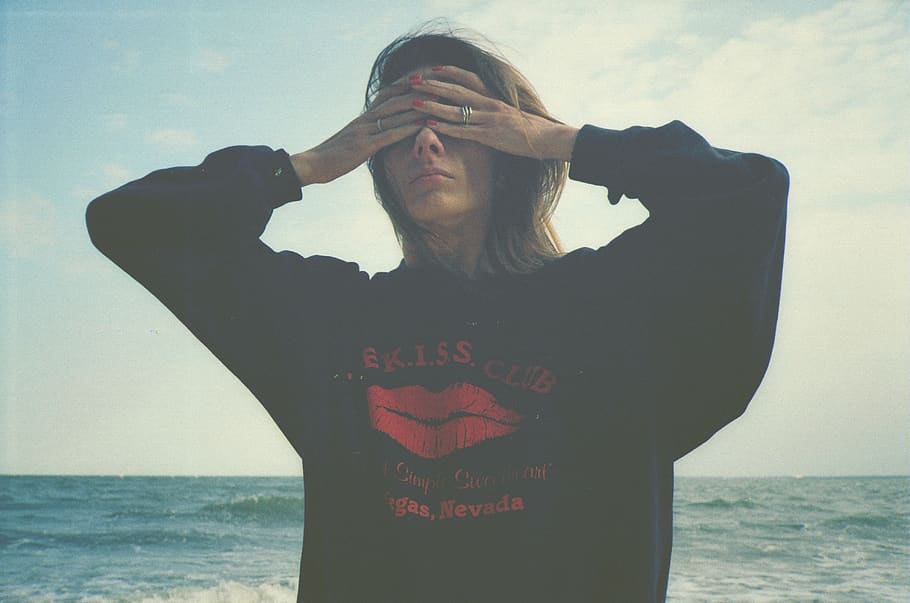 woman covering eyes by sea, clothing, apparel, sleeve, sweater