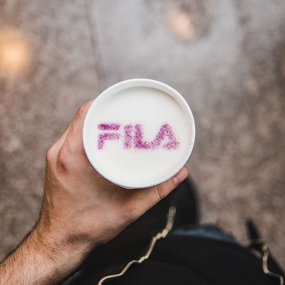 person holding cup with purple Fila text, human, egg, food, finger