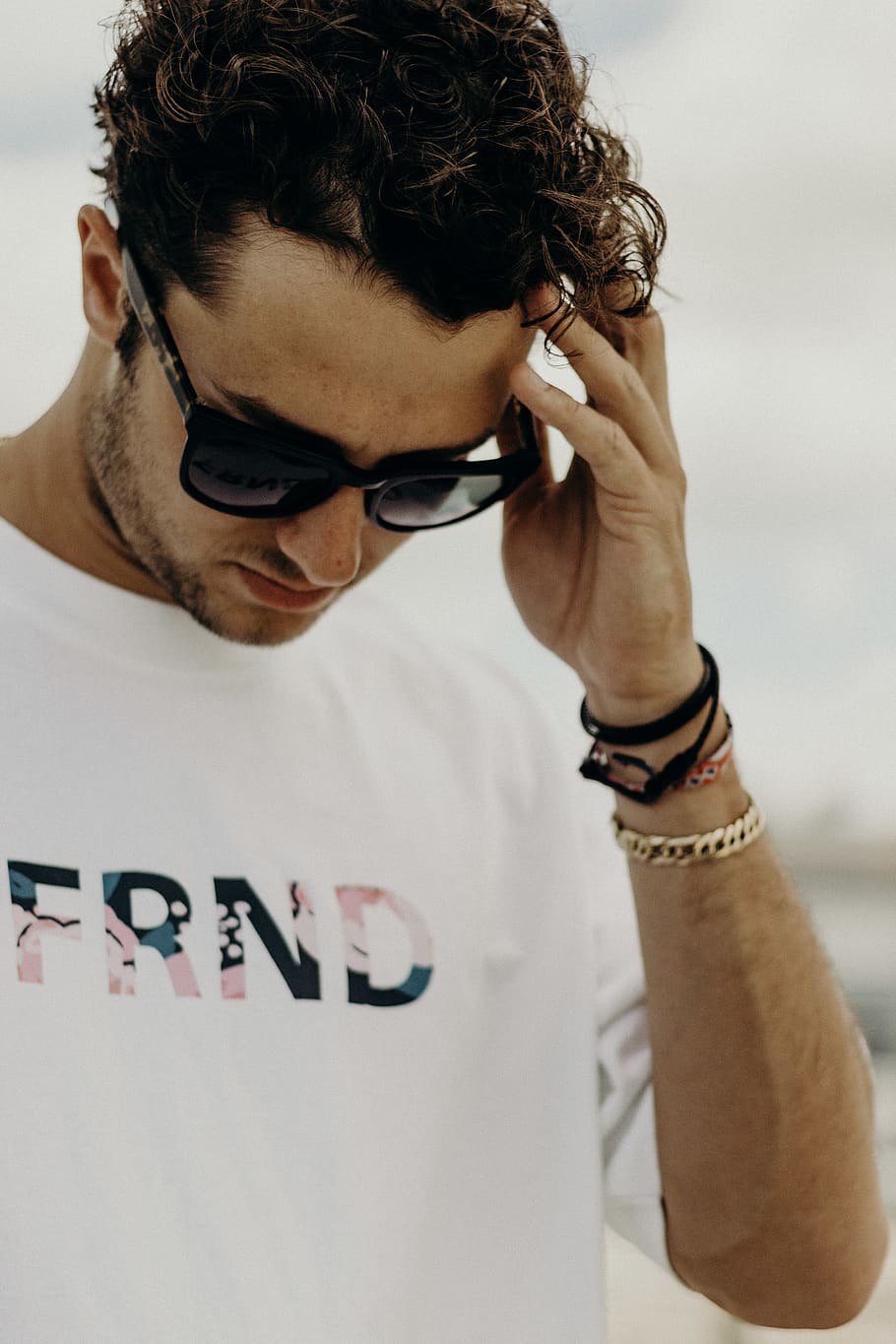 man standing and looking down while touching his head, one person HD wallpaper