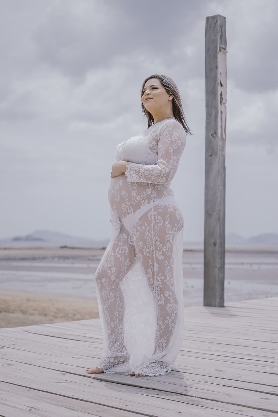 Pregnant Woman Wearing Mesh Dress Standing on Dock, attractive