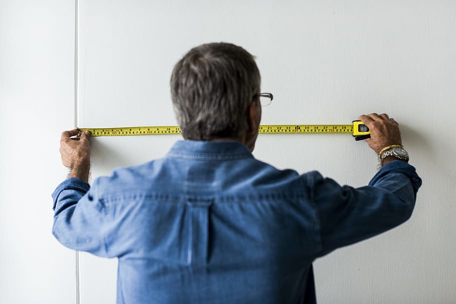 Man In Blue Collared Long Sleeved Shirt Measuring The Wall, accurate HD wallpaper