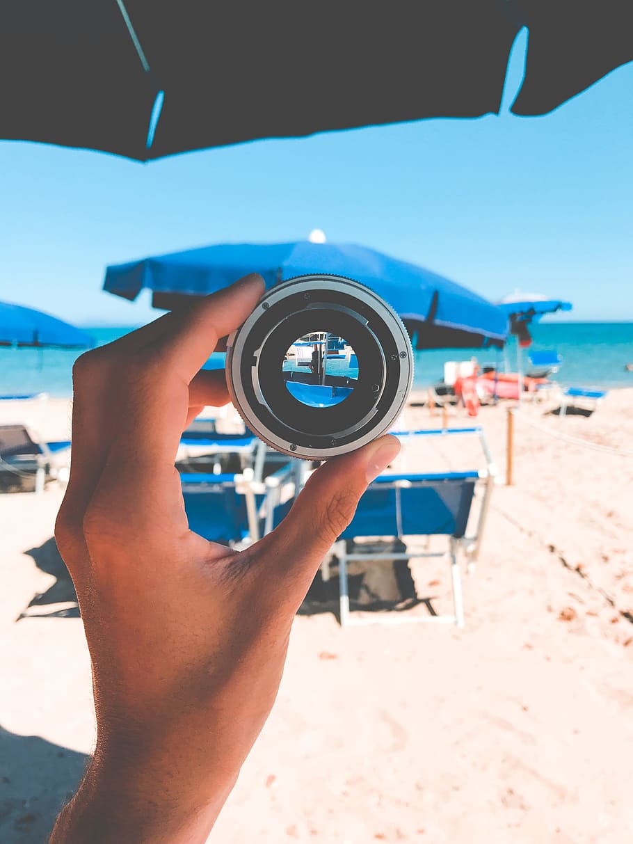 Person Holding Gray Lens, beach, beach chairs, camera lens, daytime HD wallpaper