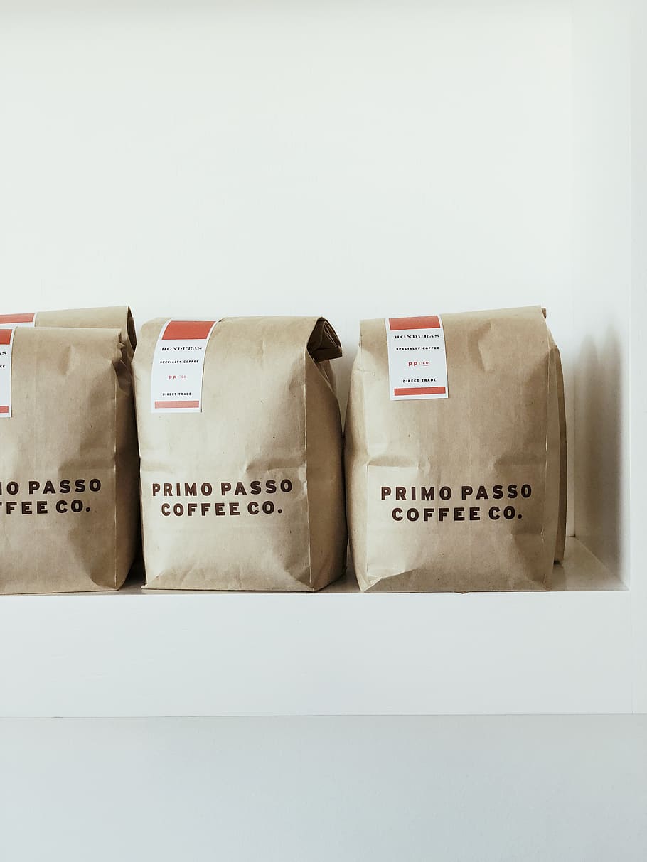 three brown Primo Passo Coffee co packs, indoors, text, western script