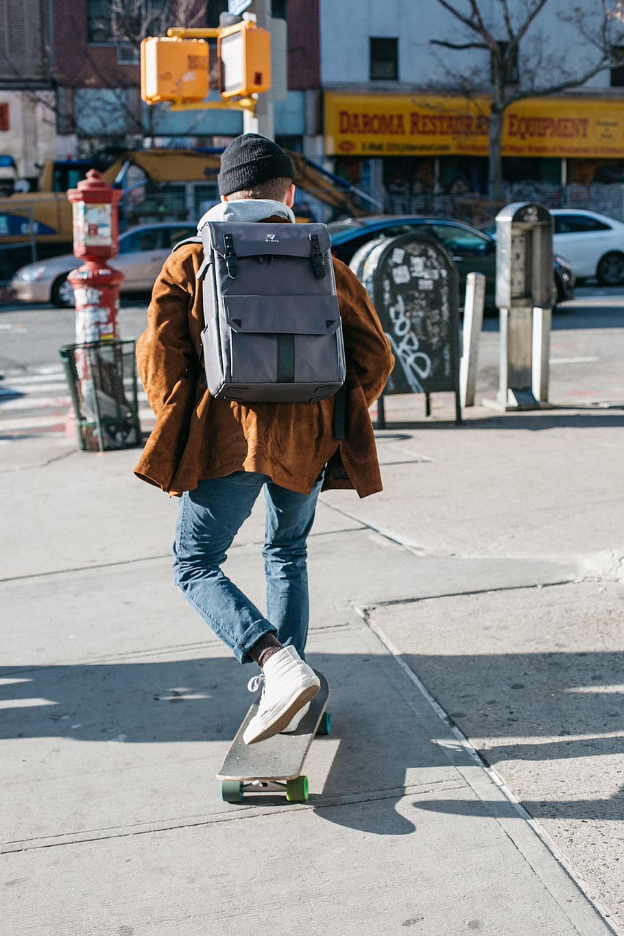 Man Wearing Brown Jacket, Blue Denim Jeans, and White Shoes Riding Skateboard on Sideway HD wallpaper