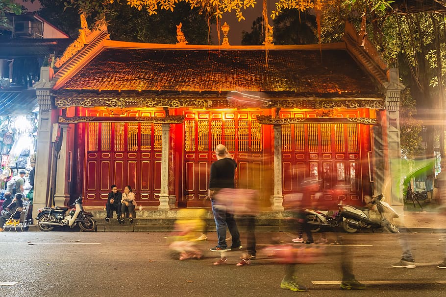 man in black shirt standing in front of brown and black ancestral house, HD wallpaper