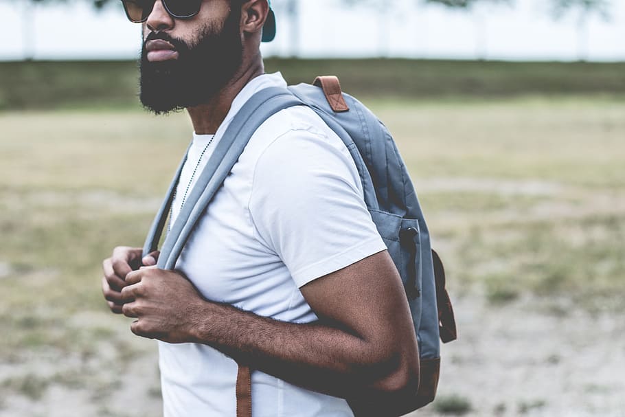 man in white tank top holding his bag, backpack, sunglass, person